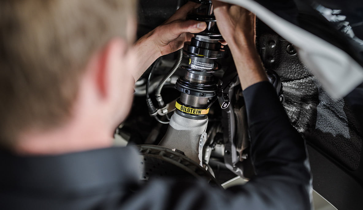 Ein KFZ-Mechaniker baut ein BILSTEIN EVO SE Gewindefahrwerk in einen Porsche 992 ein