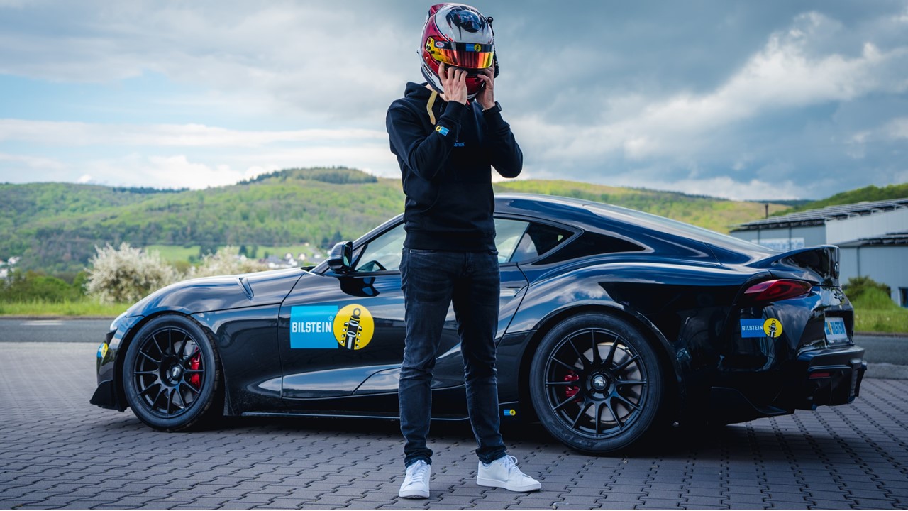 Ein Rennfahrer steht vor einem Trackday Auto