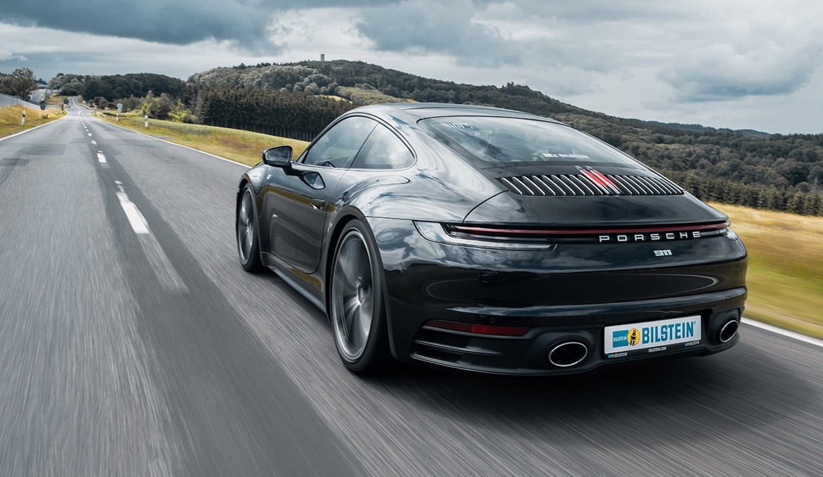 Porsche 992 drives on a country road with BILSTEIN coilover suspension